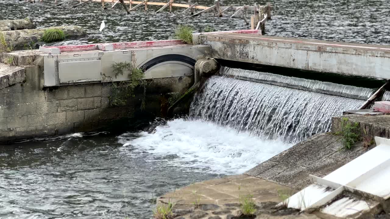 el río oi fluye río abajo a través de una pequeña presa en arashiyama, kyoto, japón