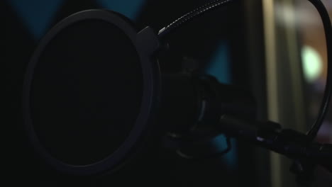 Black-studio-microphone-with-a-pop-filter-in-recording-studio