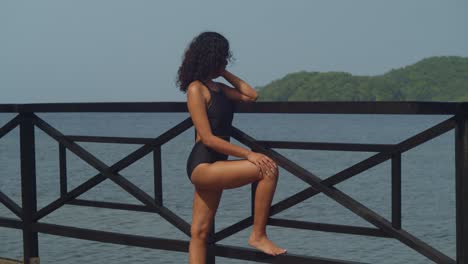 strolling down the boardwalk, a bikini-wearing girl enjoys the warm caribbean breeze and beach.