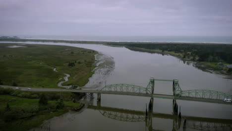 Drone-flying-over-Bullards-Bridge-in-Bandon-Oregon,-showing-traffic-crossing-the-structure