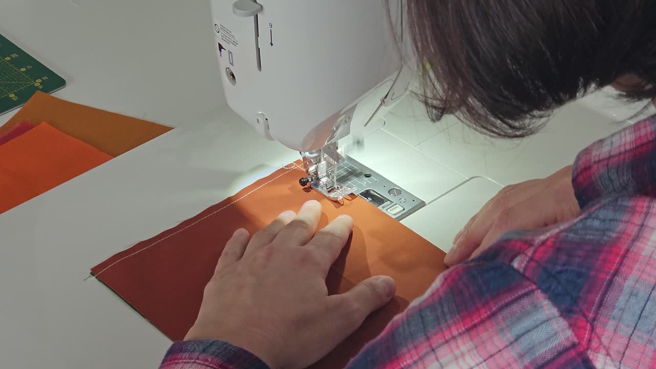 proceso de creación de colchas de patchwork - costura en la máquina de coser - desde atrás