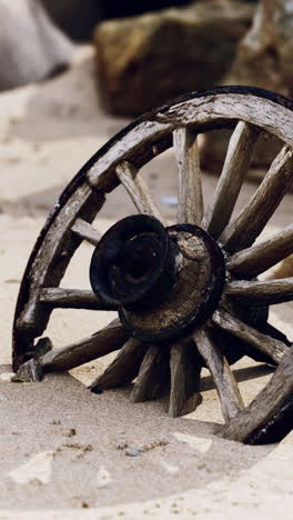 old wooden wheel on the beach