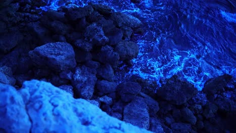 dohene shot of a stony rocky coast of france hitting the waves at night