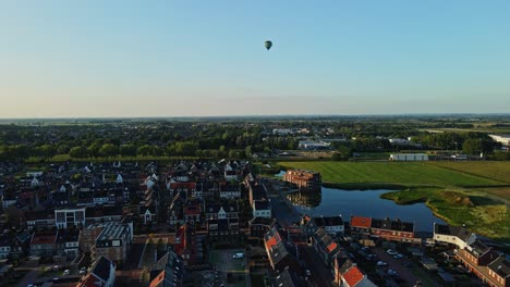 Antena-De-Una-Ciudad-Recién-Construida-Con-Un-Globo-Aerostático-Distante-En-Un-Cielo-Azul