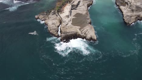 aerial view of waves hitting the reef seen from above, located on klayar beach, pacitan, indonesia