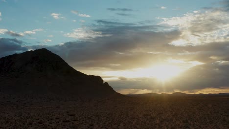 aerial pan of bright sun and storm clouds in mojave desert mountain panorama