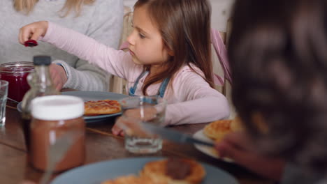 Glückliche-Familie,-Die-Frühstückswaffeln-Isst,-Während-Kinder-Zu-Hause-Köstliche-Leckereien-In-Der-Küche-Genießen