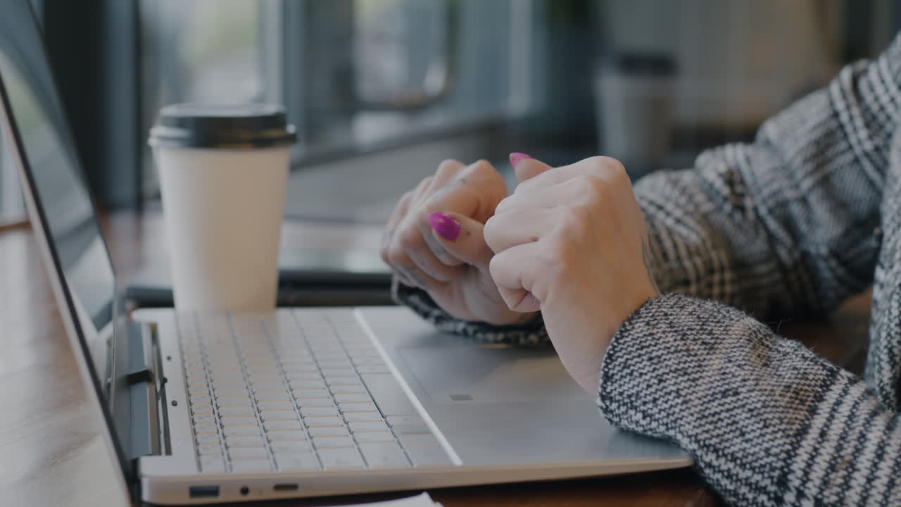 mujer trabajando en una computadora portátil en una cafetería