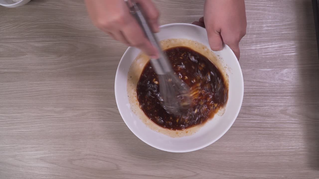 Stirring ingredients for homemade sauce in white bowl