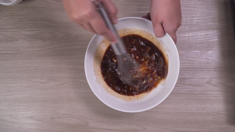 revolviendo los ingredientes para la salsa casera en un tazón blanco