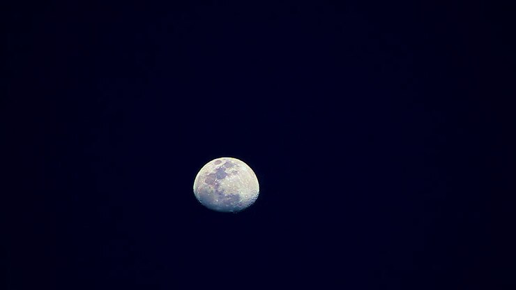 A Lua muda de cores, amarela, azul e depois roxa, movendo-se de baixo para cima na tela, em time-lapse