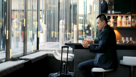 Side-view-of-Asian-Businessman-using-mobile-phone-in-the-modern-hotel-4k