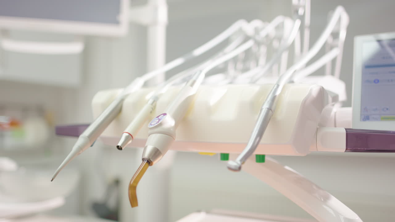 Hygienic metal dental tool is put down amongst others in clinic, closeup pan