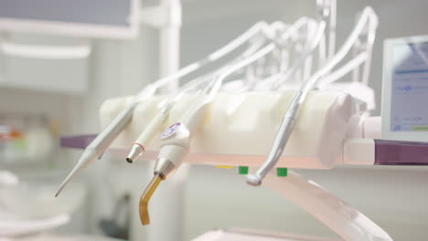 hygienic metal dental tool is put down amongst others in clinic, closeup pan