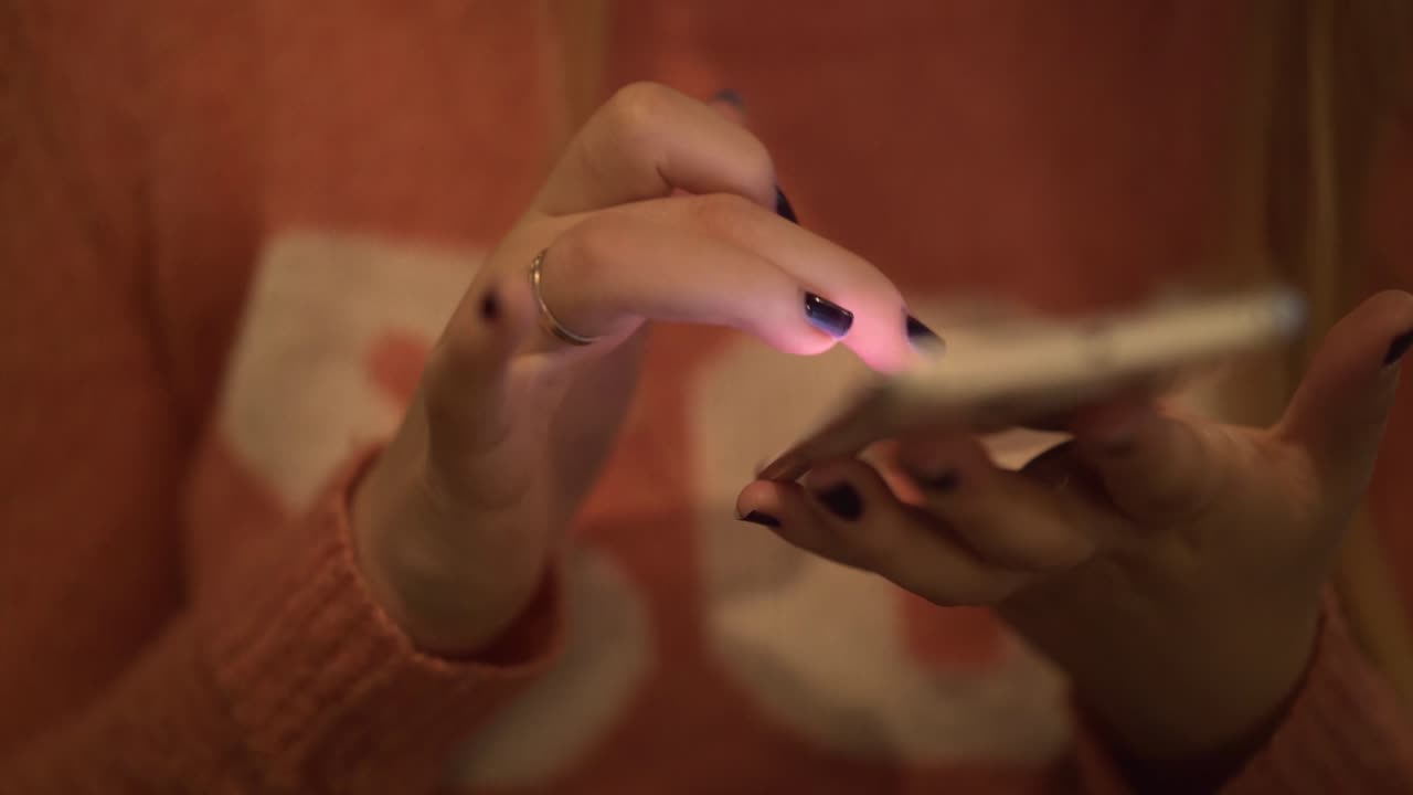 Young beautiful girl sits in a cafe works on a smartphone dials a number