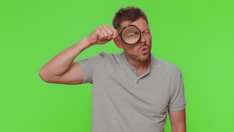 researcher scientist man holding magnifying glass near face, looking to camera with big zoomed eye