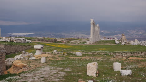 a field with a row of ancient pillars and scattered stones in laodicea