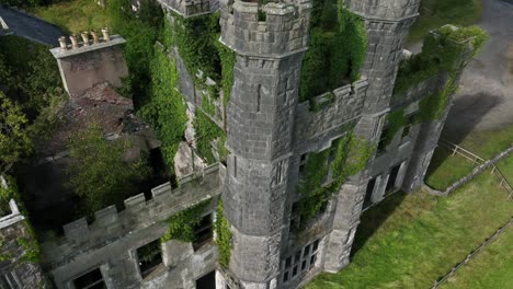 castle saunderson, county cavan, ireland, september 2022. drone pulls back and orbits clockwise, from close view to wide of the ruined castle with lawns in front with green grass and cloudy sky.
