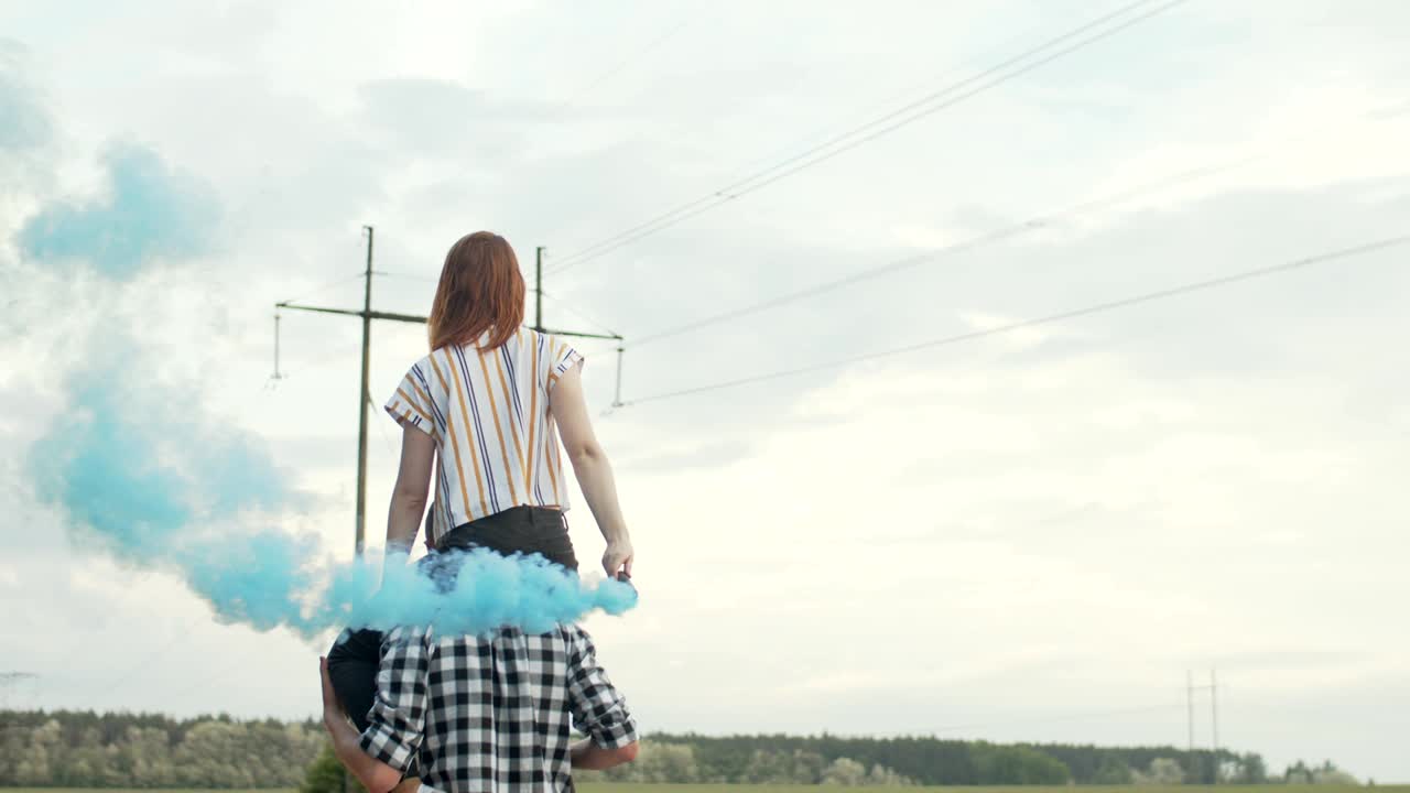 남자의 어깨에 앉아 있는 연기 폭탄을 가진 여자