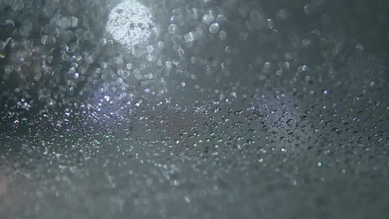 밤에는 도시 조명과 함께 흐릿한 도시 풍경, 흐릿한 배경, 도로에서 기계를 타고, 도시에서 눈이 내리고, 차 앞 유리 기기는 창문에서 눈을 청소합니다.