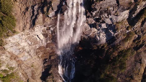 aerial drone footage pushing out with top down views of a picturesque waterfall in grindelwald in the swiss alps