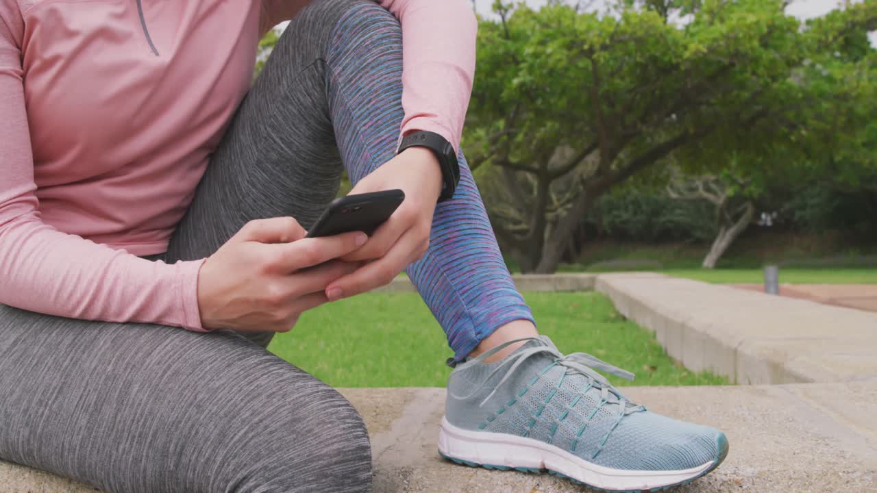 mujer caucásica en su teléfono en el parque