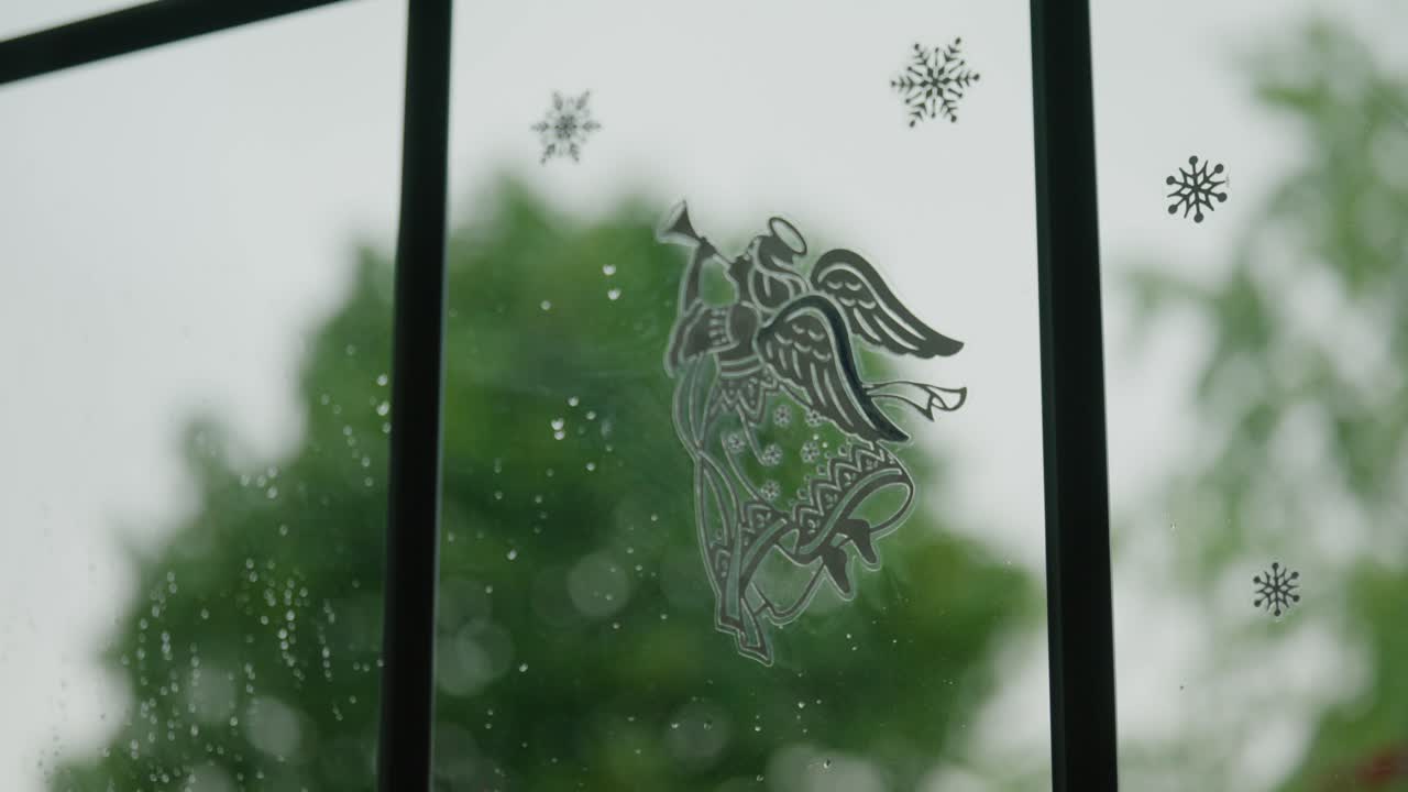 Bilde av en engel på vinduet mens kraftig stormvind blåser utenfor i Stuttgart, Tyskland, Baden-Württemberg, Europa, panorerende vinkel