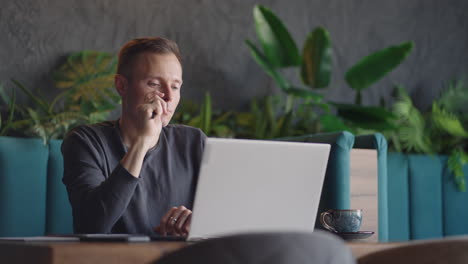 Thoughtful serious young man student writer sit at home office desk with laptop thinking of inspiration search problem solution ideas lost in thoughts concept dreaming looking away