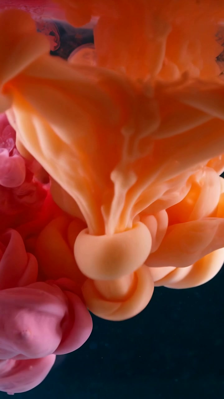 Video verticale: Pennacchio arancione che affonda e che entra in un pennacchio rosa che sale in un serbatoio di vetro dopo l'iniezione dall'alto