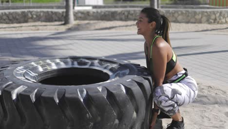 mujer tratando de levantar el neumático
