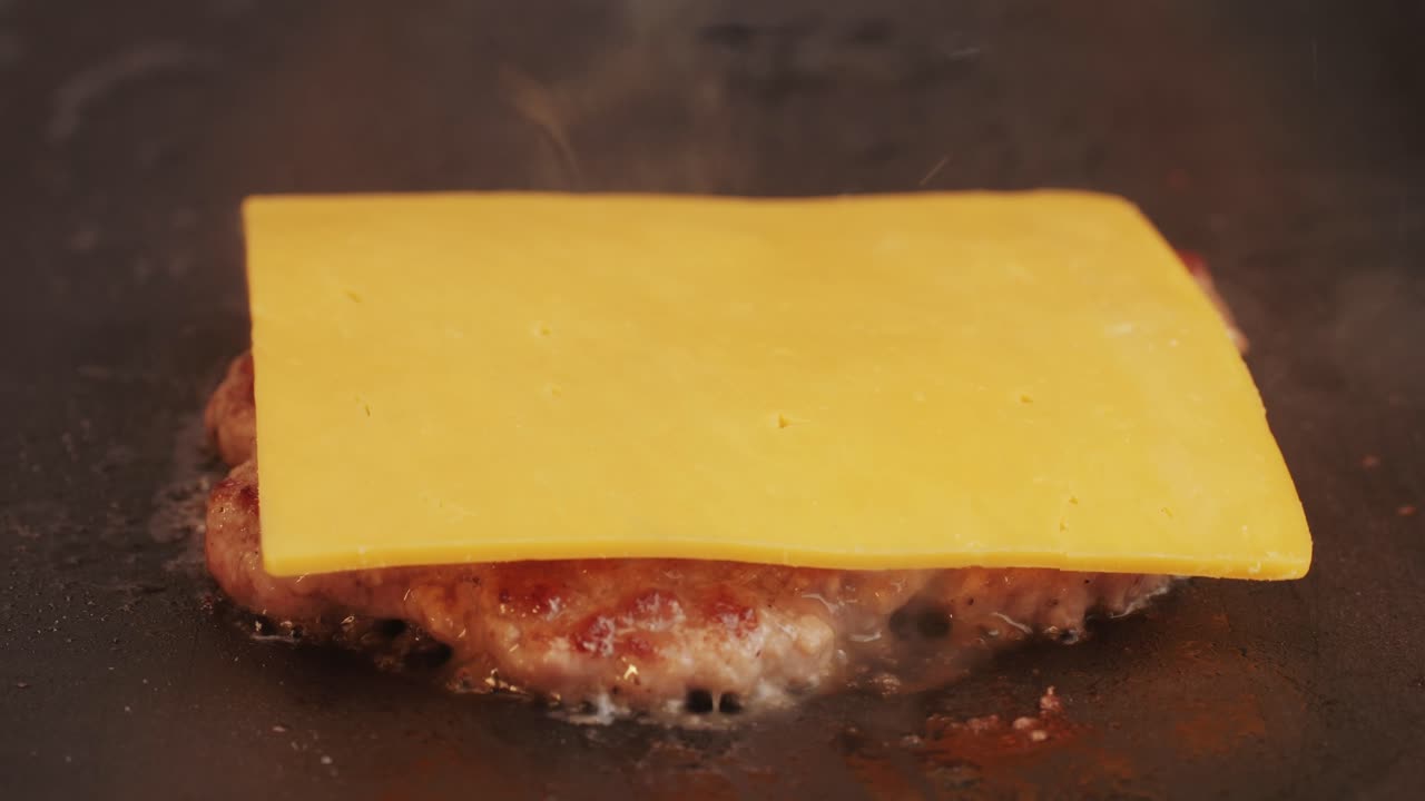 Cooking American fat smash burger on grill close-up. Beef or pork cutlet smashing by burger press. The chef in kitchen of the restaurant making cutlets for burgers - smash burger beefsteak. Fast and street food concept. High quality 4k footage