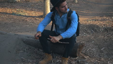 explorer sharpening a wooden stick