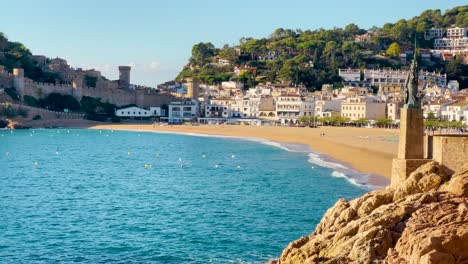 tossa de mar bay seen from the castle to the beach with coarse sand and turquoise blue sea water old walled medieval fishing village mediterranean sea