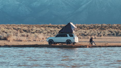 basic camping with roofnest on car in wild nature of america, aerial