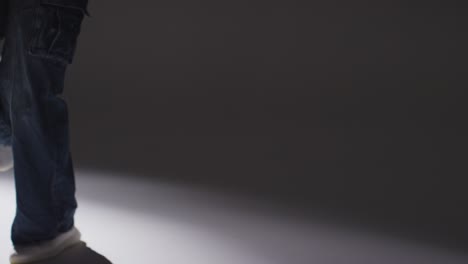 backlit studio shot of casually dressed young woman dancer dancing in spotlight 1