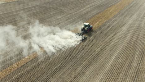 agricultural industrial tractor plows soil field for sowing in ukraine, kyiv city, aerial shot