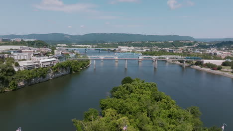 aerial view of bridges crossing the tennessee river in downtown chattanooga with lush greenery and city skyline