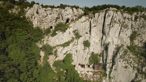 Drohnenaufnahme-Eines-Bergsabotins,-Klippenseite-Mit-Grün