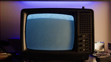 a retro tv displaying static noise, creating a nostalgic vintage atmosphere with blue and green hues.