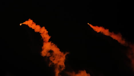 Two-marine-emergency-smoke-flares-burning-in-water,-orange-smoke-signal