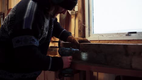 un hombre está haciendo agujeros en la madera usando un taladro en indre fosen, condado de trondelag, noruega - toma estática