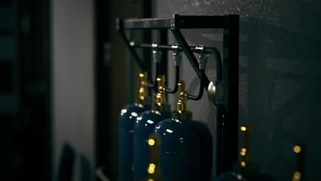 industrial gas cylinders organized on metal rack in a workshop area