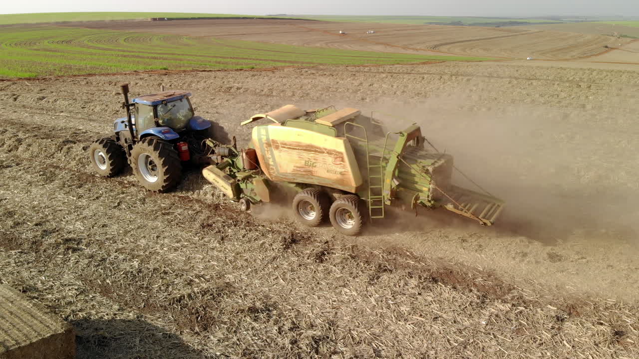 Sugar cane straw baler working in the field after harvesting the crop