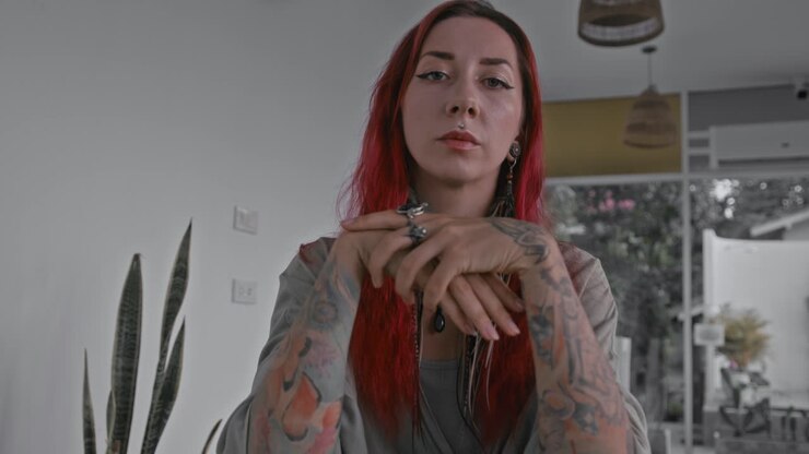 Una mujer de cabello rojo y tatuajes