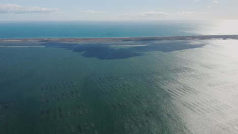 Sea-and-sky-aerial-view-of-mediterranean-shoreline-along-the-Etang-de-Thau-sunny