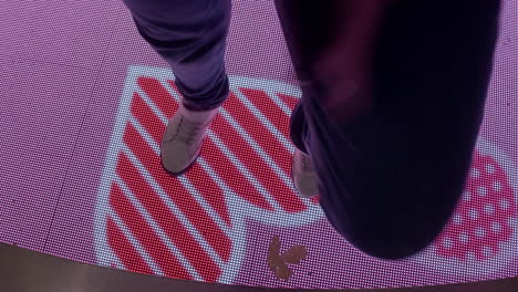 teenager dancing on interactive floor display with hearts