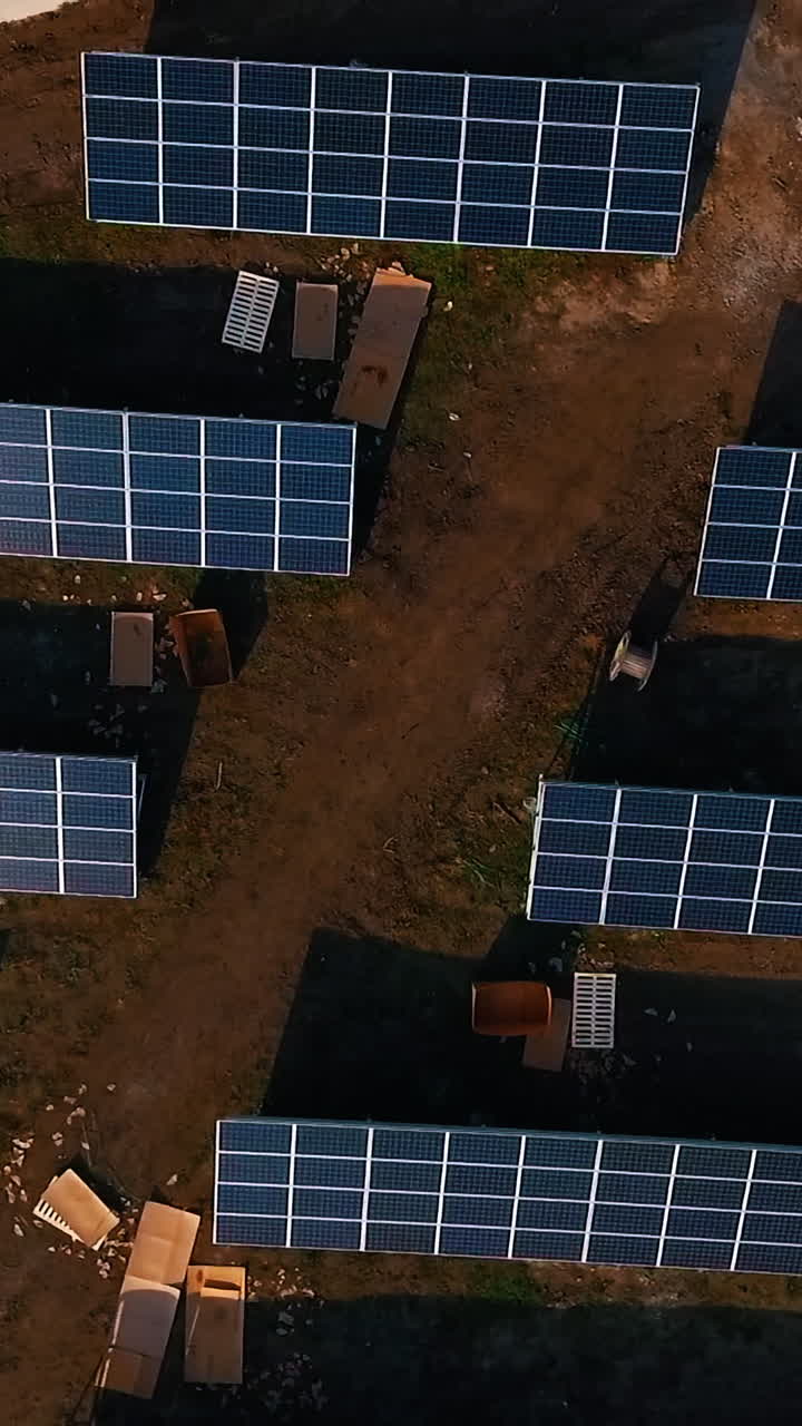 Solar panels in field. Renewable energy, technology, electricity, service, green power. View from above. Video from drone. Vertical video