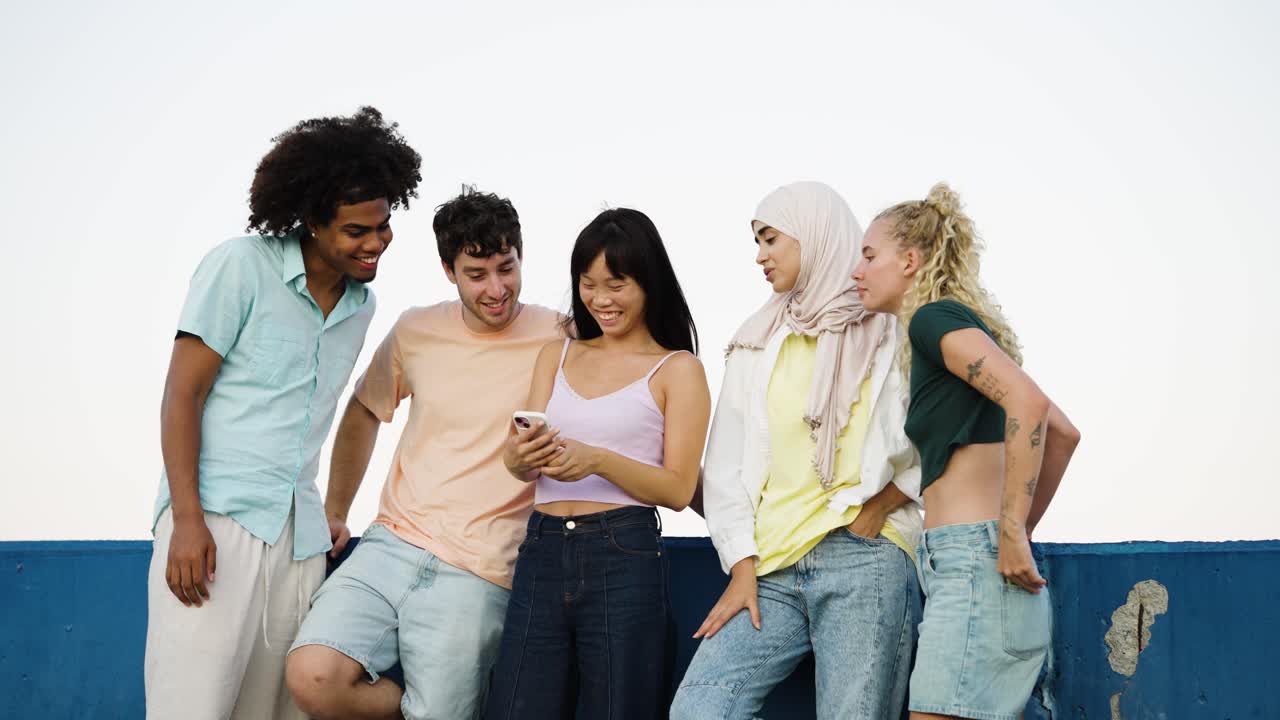Gruppo di giovani adulti che socializzano e usano i telefoni all'aperto