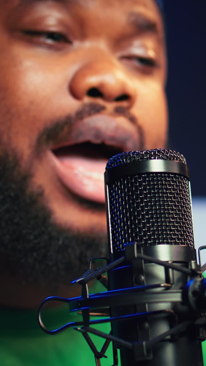 Uomo afroamericano che parla in un microfono da studio