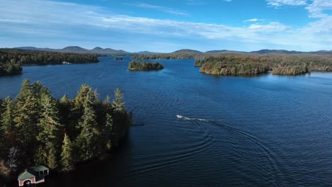 boat cruising across squam lake in new hampshire, united states